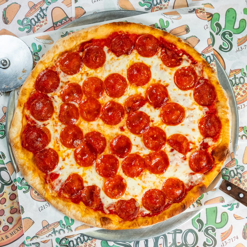 Whole pepperoni pizza with melted cheese on a metal tray, surrounded by colorful Sonora’s Pizzeria and Mexican Restaurant paper.